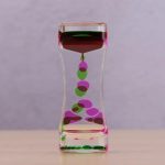Ampulheta com óleo líquido colorido, bolhas de diferentes tamanhos a mover-se entre os compartimentos.