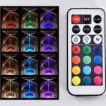 Ampulheta luminosa com várias cores de luz, controlada por um comando remoto com botões de cores e funções de iluminação.