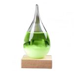 Vaso de vidro alongado com líquido verde fluorescente, colocado sobre uma base de madeira, usado em demonstrações científicas de plasma.