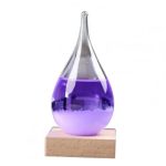 Lâmpada de plasma com líquido violeta, forma de gota, sobre base de madeira, com efeito de luz interior brilhante e movimento de partículas.