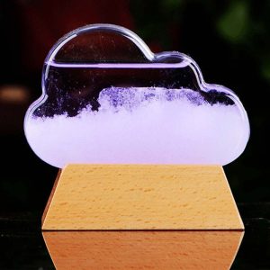 Cristal em forma de nuvem com líquido dentro, apoiado numa base de madeira, mostrando variações de nível de líquido.