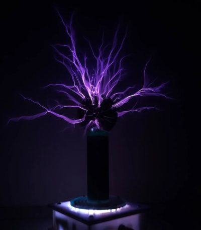 Descarga elétrica visível com raios violetas a partir de uma bobina de Tesla em ambiente escuro.