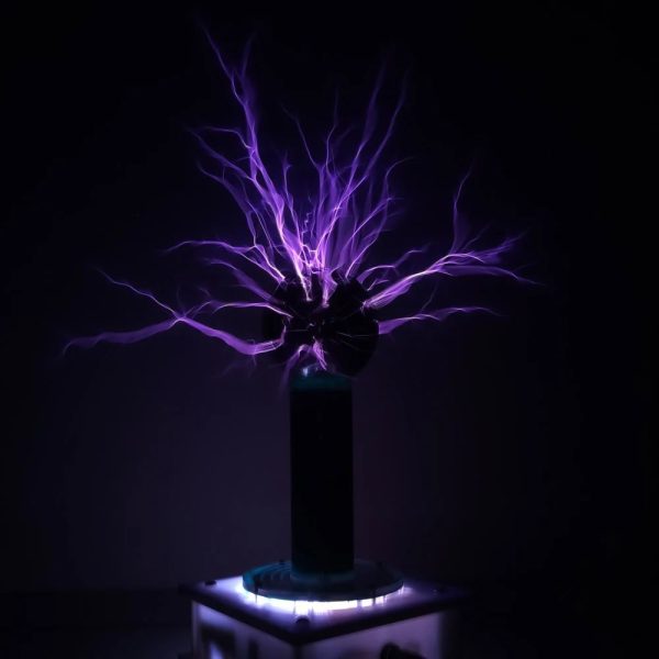 Descarga elétrica visível com raios violetas a partir de uma bobina de Tesla em ambiente escuro.