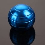 Bola giroscópio azul com superfície metálica brilhante, refletindo luz, sobre fundo escuro.