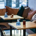 Calendários perpétuos com tema de astronauta em cores violeta, exibidos em mesas de café com decoração moderna e iluminação natural.