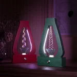 Duas lâmpadas de plasma com efeito de água em movimento, uma vermelha e uma verde, em suporte de madeira, com iluminação colorida ao fundo.
