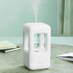 Lâmpada de plasma com efeito de luz estroboscópica, visível a partir de diferentes ângulos, com vapor de plasma visível no topo, em ambiente de escritório com livros e cortina verde.
