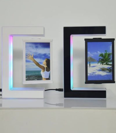 Dois candeeiros com porta-retratos em levitação, um branco e um preto, exibindo imagens de praia e natureza, com iluminação LED colorida ao redor.