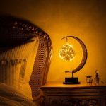 Luminária de lua crescente com esfera de plasma brilhante, colocada numa mesa ao lado da cama, criando um ambiente acolhedor e científico.