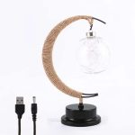 Candeeiro de lua com base preta, braço envolto a corda de sisal, lâmpada de vidro com filamentos decorativos, ligado a cabo USB e adaptador de energia.