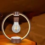 Candeeiro de levitação com lâmpada de filamento visível, estrutura circular de madeira, base e suporte suspensos, ambiente com iluminação quente.