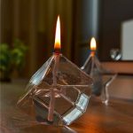 Frascos de vidro em forma de cubo com lâmpadas de plasma acesas, exibindo cores quentes e efeitos de luz.