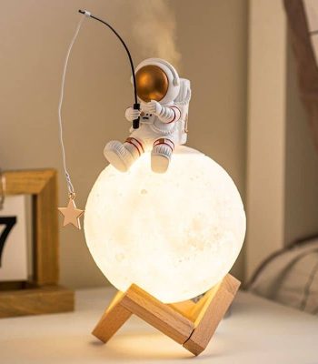 Lâmpada de mesa em forma de lua com figura de astronauta a pescar uma estrela, decorativa e educativa para quartos infantis.