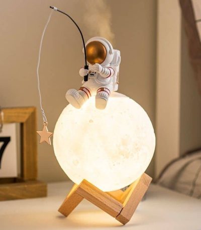 Lâmpada de mesa em forma de lua com figura de astronauta a pescar uma estrela, decorativa e educativa para quartos infantis.