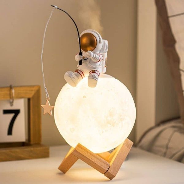 Lâmpada de mesa em forma de lua com figura de astronauta a pescar uma estrela, decorativa e educativa para quartos infantis.