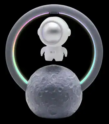 Candeeiro de mesa com figura de astronauta, anel de luz LED colorido e base em forma de lua, ideal para decoração científica e educativa.