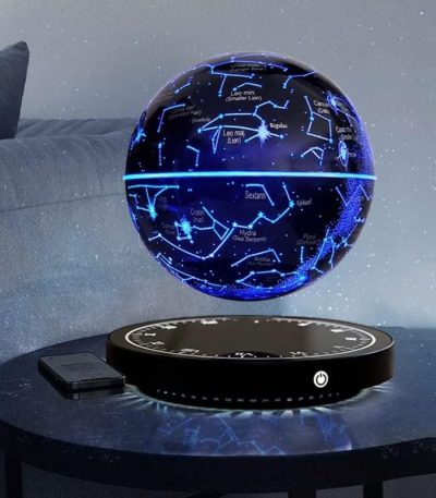 Lâmpada de mesa com projeção de constelações e estrelas, esfera luminosa azul com mapas celestiais, base preta com controle.