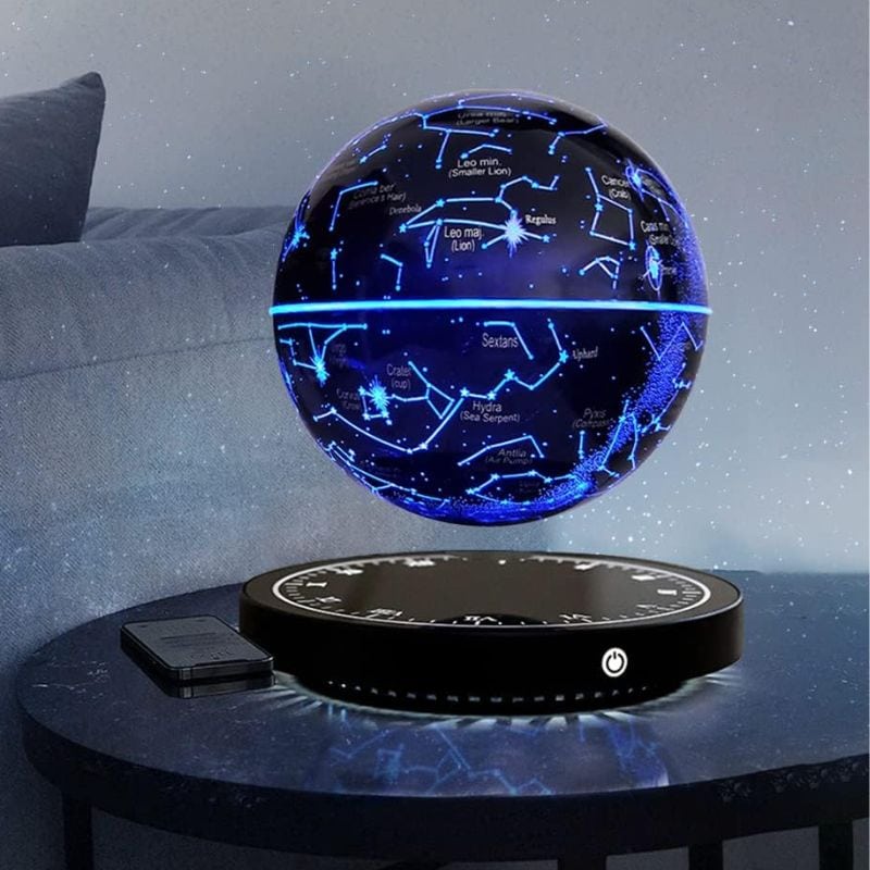 Lâmpada de mesa com projeção de constelações e estrelas, esfera luminosa azul com mapas celestiais, base preta com controle.