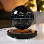 Candeeiro de presença com esfera que mostra constelações e estrelas, base iluminada com luz branca, ambiente acolhedor e decorativo.