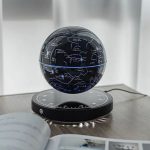 Globo de constelações com mapa celeste iluminado, apoiado numa base circular com escala de horas, ligado a uma fonte de energia.