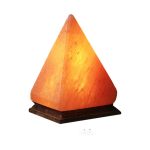 Lâmpada de sal em forma de pirâmide, iluminada, sobre base de madeira escura, com luz quente.