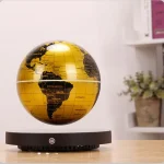 Globo terrestre dourado em levitação sobre base negra, com detalhes de continentes e oceanos visíveis, em ambiente de loja de gadgets científicos.