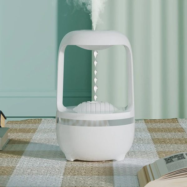 Humidificador com design futurista, forma de cápsula com base redonda, emitindo vapor de água, em ambiente com cortinas verdes e chão de tapete.