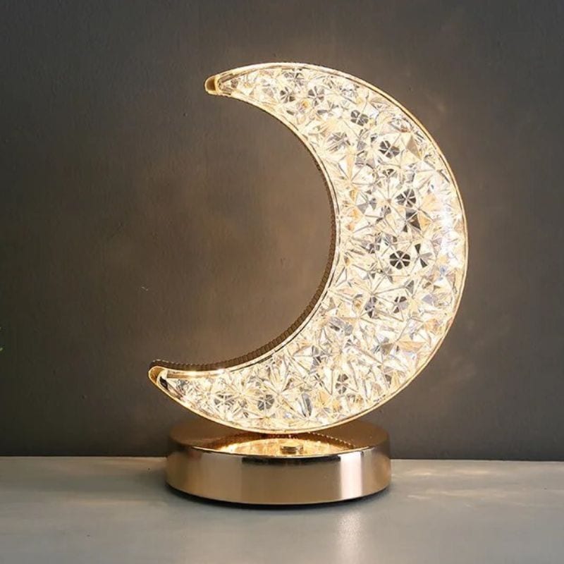Luminária de lua em acrílico com detalhes brilhantes, base metálica dourada, iluminação suave, ideal para decoração de quarto ou sala.