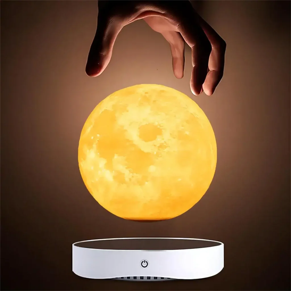 Mão a segurar uma réplica da Lua iluminada, suspensa acima de uma base de levitação.
