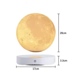 Candeeiro em forma de lua com 20cm de diâmetro, levitando acima de base circular de 17cm de largura e 3.3cm de altura, com luz amarelada.