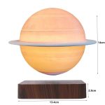 Lâmpada decorativa em forma de planeta Saturno com anel, iluminada, sobre base de madeira, com dimensões indicadas.