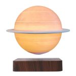 Lâmpada de Saturno com anel luminoso, iluminada, sobre base de madeira, destacando-se pelo efeito de luz e cores quentes.
