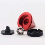 Cones giroscópicos desmontados com rolamento, base preta, tubo vermelho e tampa preta, usados em experimentos de física.