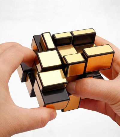 Pessoa a segurar um Cubo de Rubik Espelho com várias faces refletidas, mostrando diferentes ângulos e detalhes do produto.
