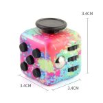 Cubo fidget com superfície de pintura a spray colorida, botões pretos e um botão giratório.
