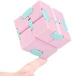 Cubo fidget infinito com peças de cor rosa e detalhes azuis, mostrado equilibrado na ponta de um dedo, destacando o seu design modular e funcionalidade.