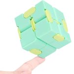 Cubo fidget com várias faces que se podem rodar, em cores pastel de verde e amarelo, com detalhes arredondados e encaixes suaves.