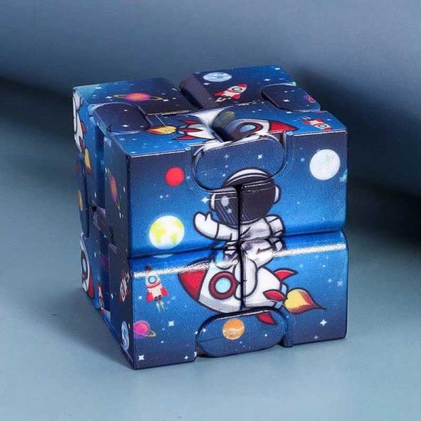 Cubo Infinito com ilustrações de astronauta, foguetes e planetas em fundo estrelado, feito de peças de plástico coloridas encaixadas.
