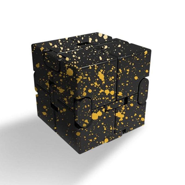 Cubo infinito de aço preto com acabamento espelhado e manchas douradas, vista frontal com detalhes das faces e cantos do produto.