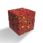 Cubo de aço vermelho com padrão de manchas douradas, vista frontal com sombra ao lado esquerdo.