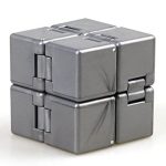 Cubo anti-stress metálico com superfície lisa e detalhes de dobradiças visíveis, mostrado de frente e ligeiramente de lado.