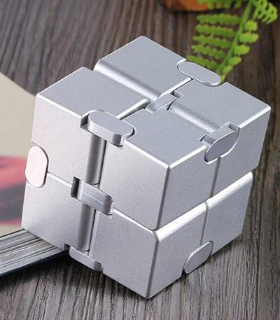 Cubo infinito de metal com ligações articuladas, mostrando diferentes ângulos e detalhes das conexões.