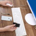 Teclado de computador, rato, smartphone e cubo de manipulação na mesa de trabalho.