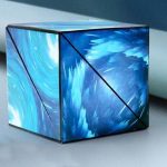 Cubo de origami com padrão de água em tons de azul, com linhas pretas que destacam as faces e o efeito de movimento na superfície.