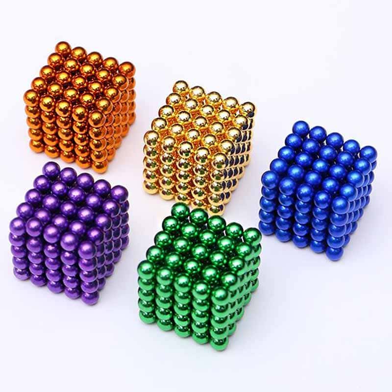 Cubo magnético composto por bolas de cores diferentes: laranja, dourado, azul, roxo e verde, formando um cubo tridimensional.