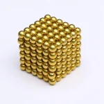 Cubo de bolas magnéticas douradas, mostrando várias faces e detalhes das esferas brilhantes, com fundo branco.