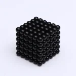 Cubo de bolas magnéticas pretas, mostrando várias faces e detalhes de cada esfera, com foco na textura e na disposição ordenada das bolas.