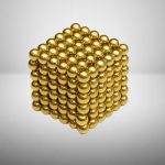 Cubo magnético dourado composto por bolas de 3mm, formando uma estrutura tridimensional de 6x6x6 unidades, com acabamento brilhante e refletivo.