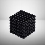 Cubo magnético preto composto por bolas de 3mm, formando um cubo perfeito com superfície lisa e brilhante, visto de frente com fundo branco.