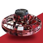 Drone com estrutura circular transparente vermelha, hélices internas e componentes visíveis, vista superior em fundo branco com sombra.